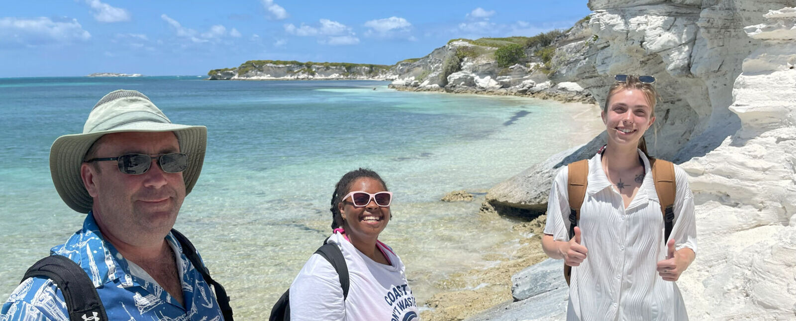 Students stand with Dr. Daniel Kjar near a set of cliffs in The Bahamas. 