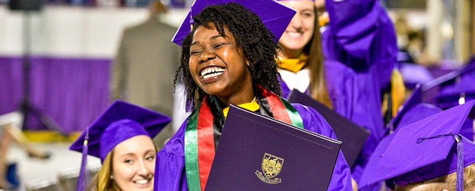 A female graduate smiles after receiving her degree