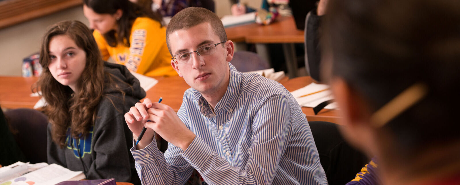 Students look at teacher in a classroom setting. 