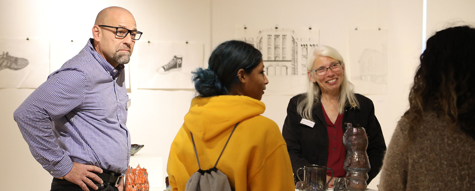 Art faculty members speak with students in the George Waters Gallery