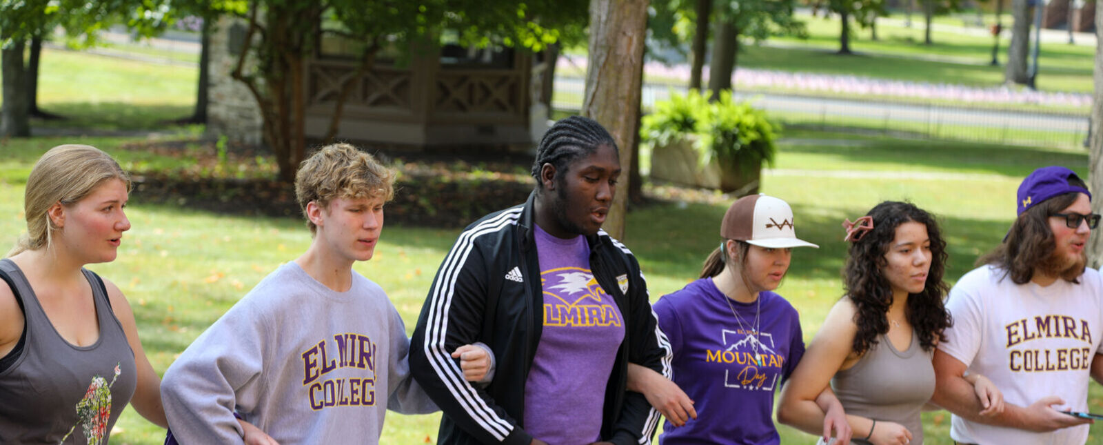 Elmira College students lock arms as they sing the Alma Mater on Mountain Day. Mark Twain's study can be seen in the background. 