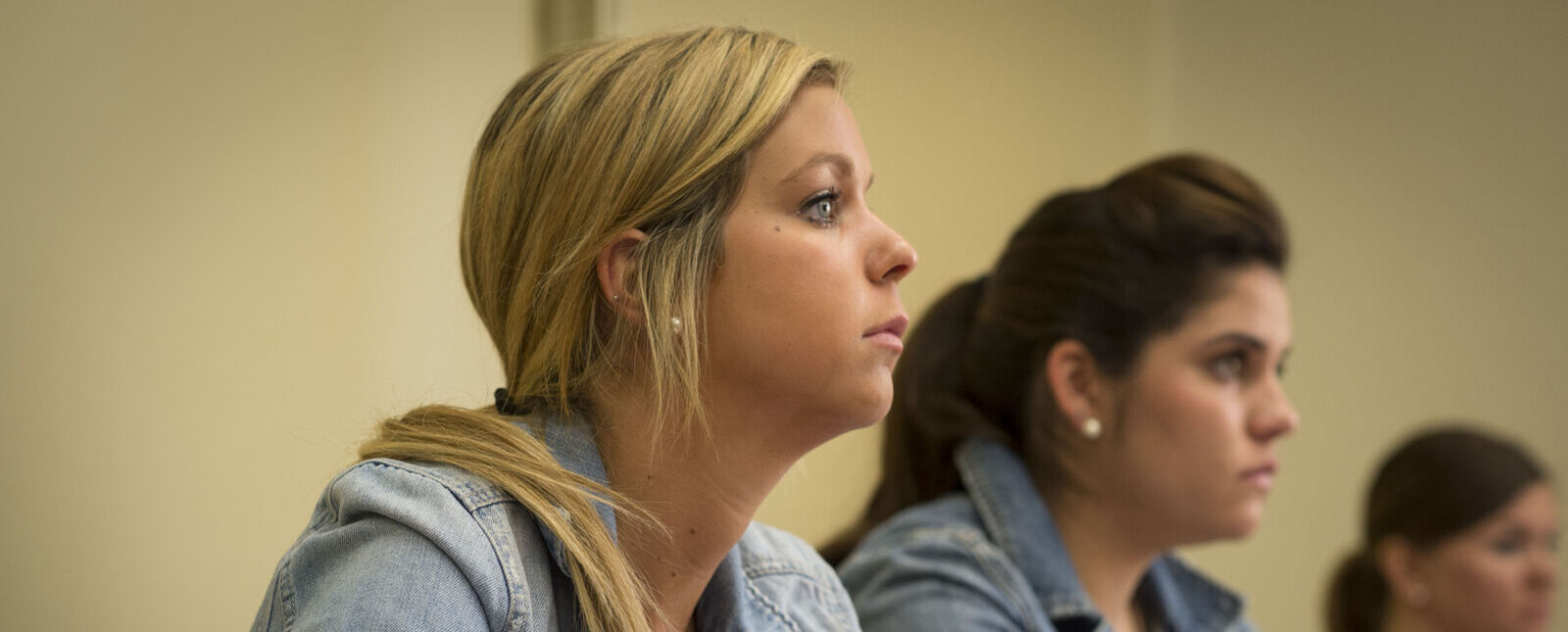 Two female students listen during a class