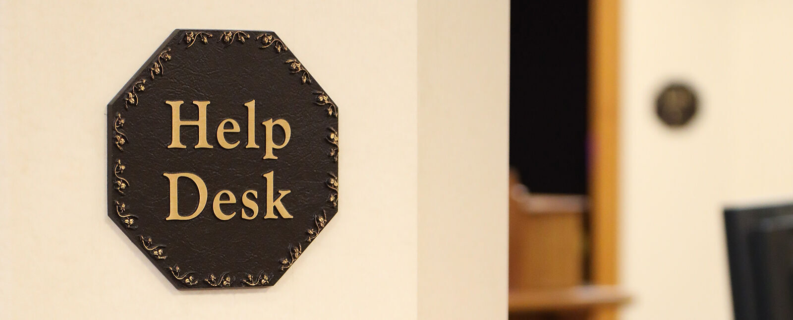 An octagonal Help Desk sign sits at the entrance to the IT department
