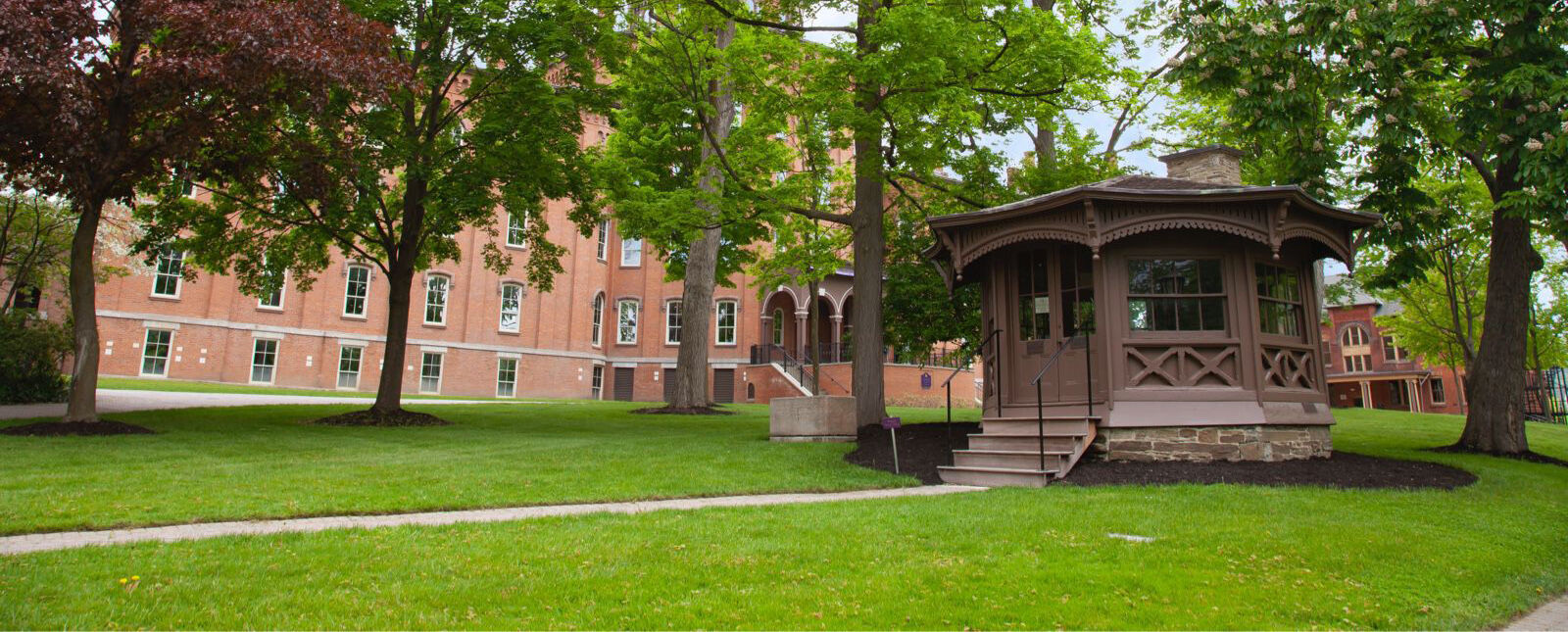 The Mark Twain Study is pictured in front of a line of trees and Cowles Hall
