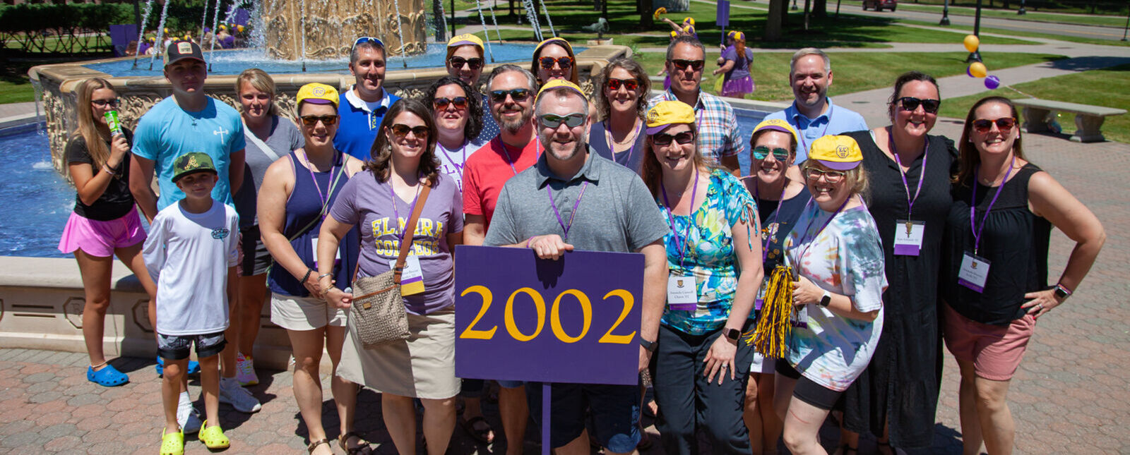Class of 2022 members stand with a 2022 sign in front of the fountain during a reunion.
