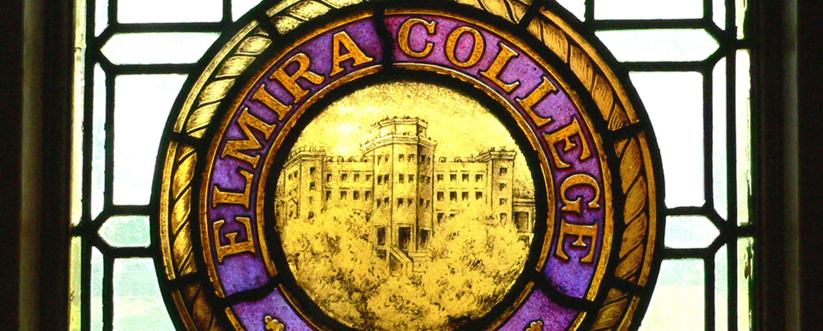 A stained glass window depicts the Elmira College seal
